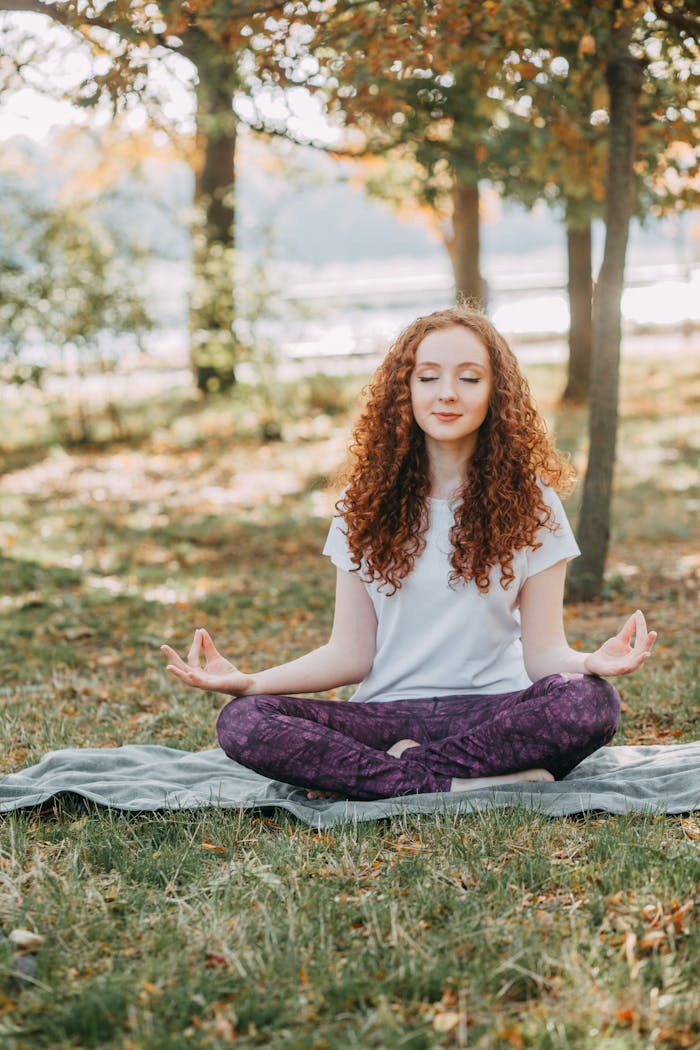portfolio-06 Woman meditating in a serene park during springtime, fostering relaxation and mental wellness.